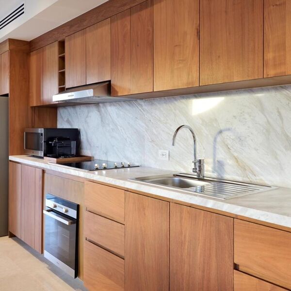 Modern wood kitchen with marble backsplash and full cooking essentials