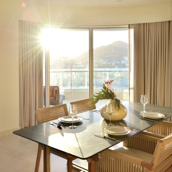 Sunlit dining area with balcony access and beautiful mountain views