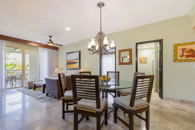 Bright dining area with elegant chandelier and private balcony access