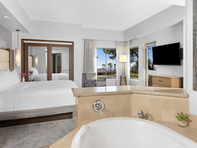 Bright resort-style suite with soaking tub and scenic outdoor views