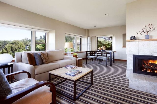 Bright living room with fireplace, dining space, and scenic window views