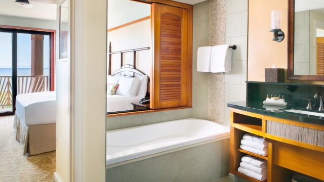 Spa-style bathroom with soaking tub and ocean-view bedroom access