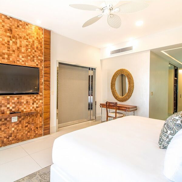 Bright modern bedroom with wood accents, TV, and stylish workspace