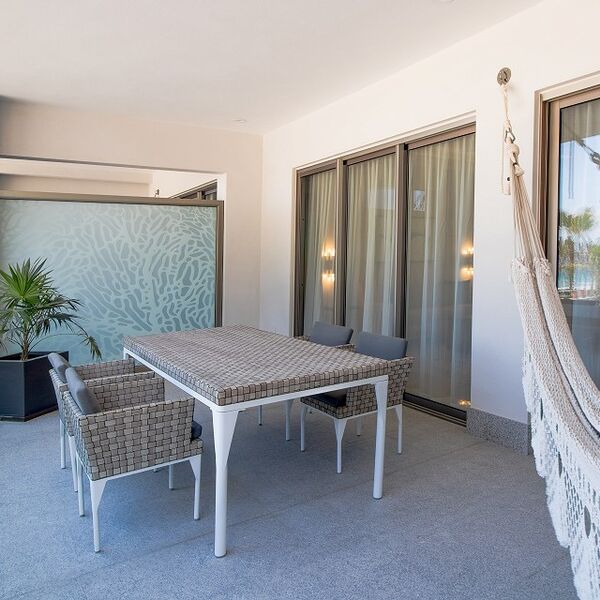Private covered patio with outdoor dining and a relaxing hammock