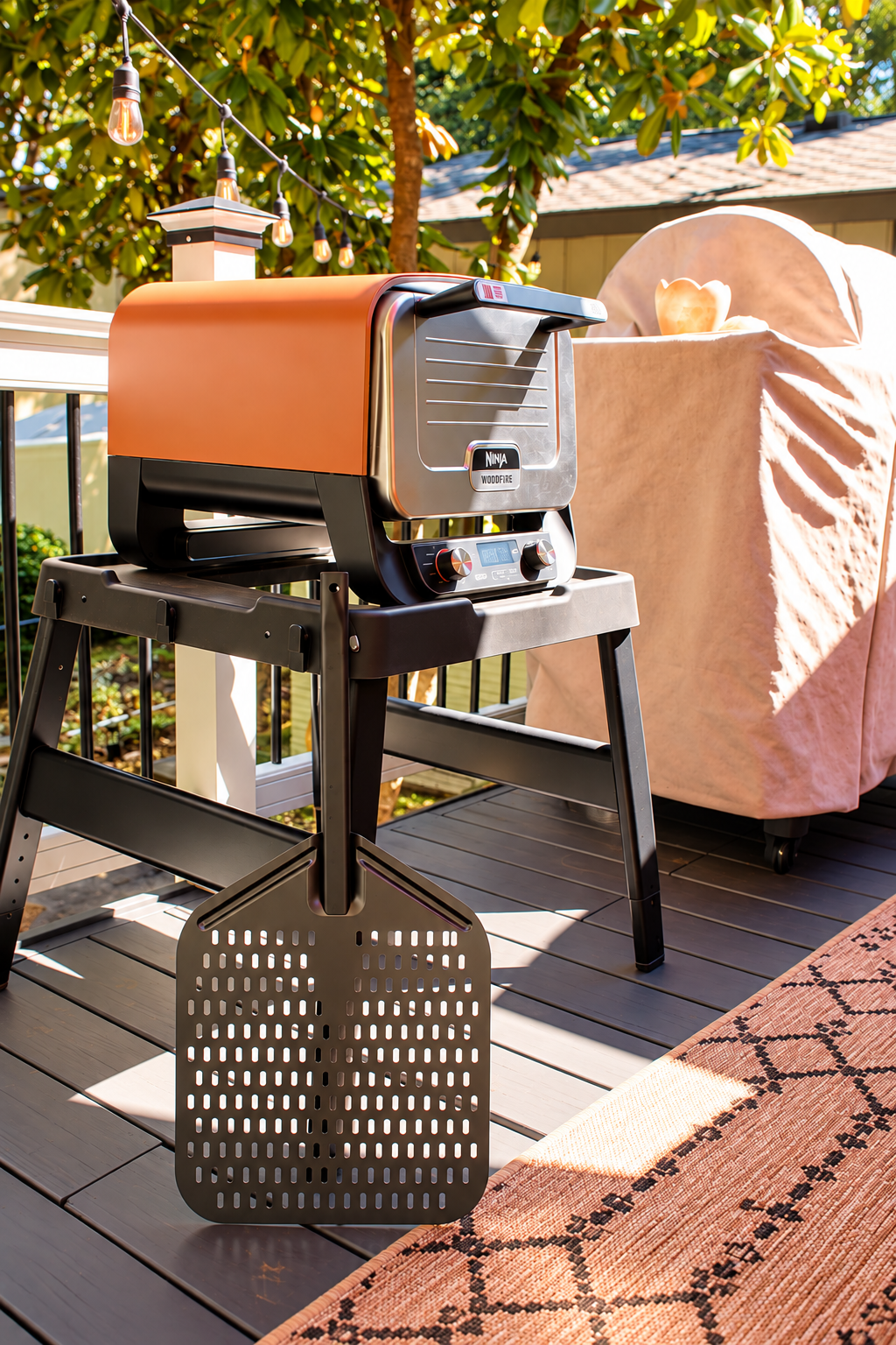 A Ninja pizza oven sits ready like an Italian would build it: wood smoke rising, friends gathered close, the whole night built around flame and dough and the ritual of feeding people you love.