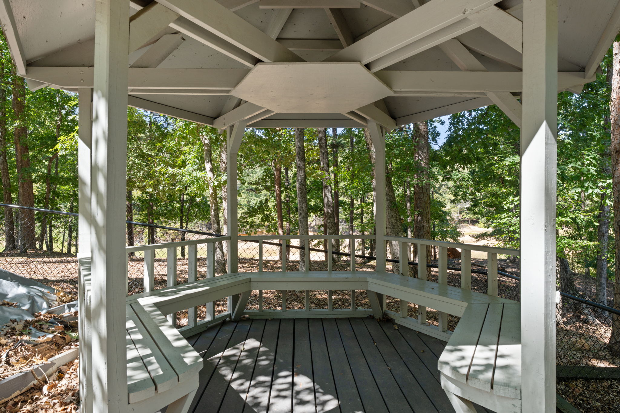 An open-air gazebo nested in trees: the perfect place to pause, sit, and let the woods quiet your mind.