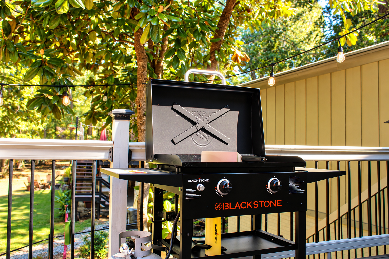Cook like a chef: Blackstone griddle, grill, wood-fired oven, and string lights turning every meal into an event.