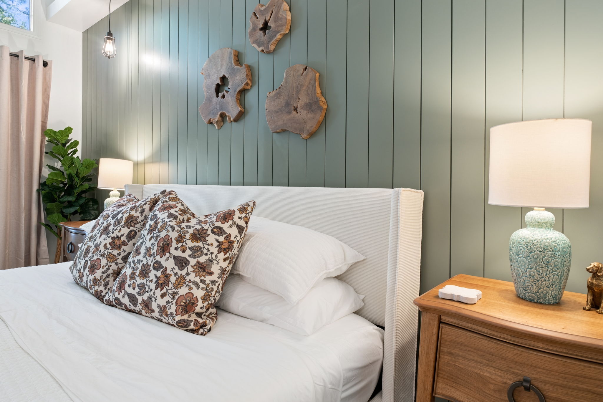 Serene king bedroom with sage accent wall and warm rustic-modern details