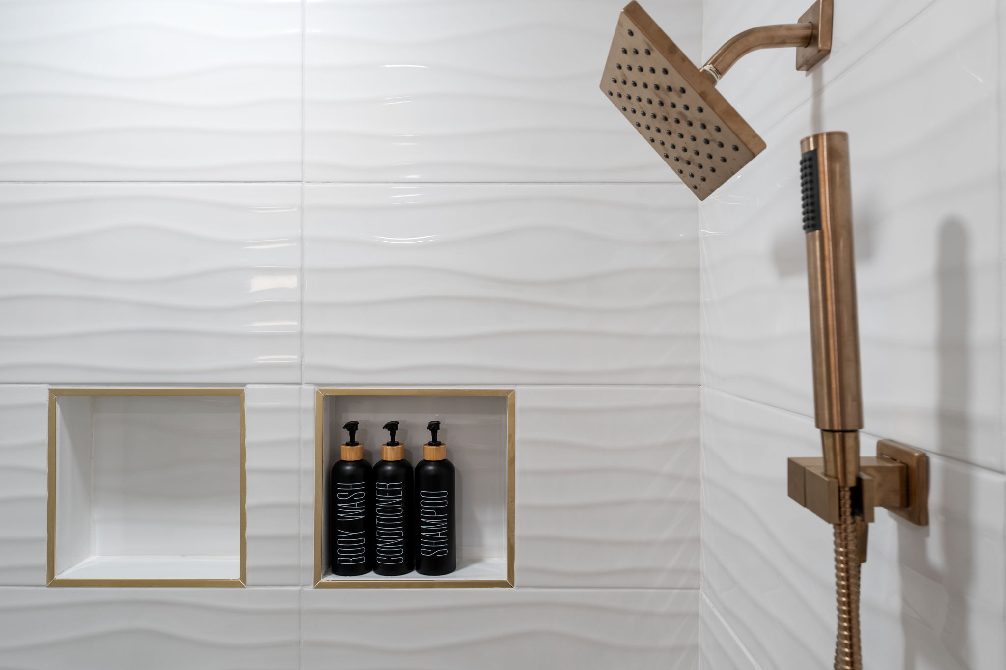 Spa-like walk-in shower with brass fixtures and sleek built-in niches
