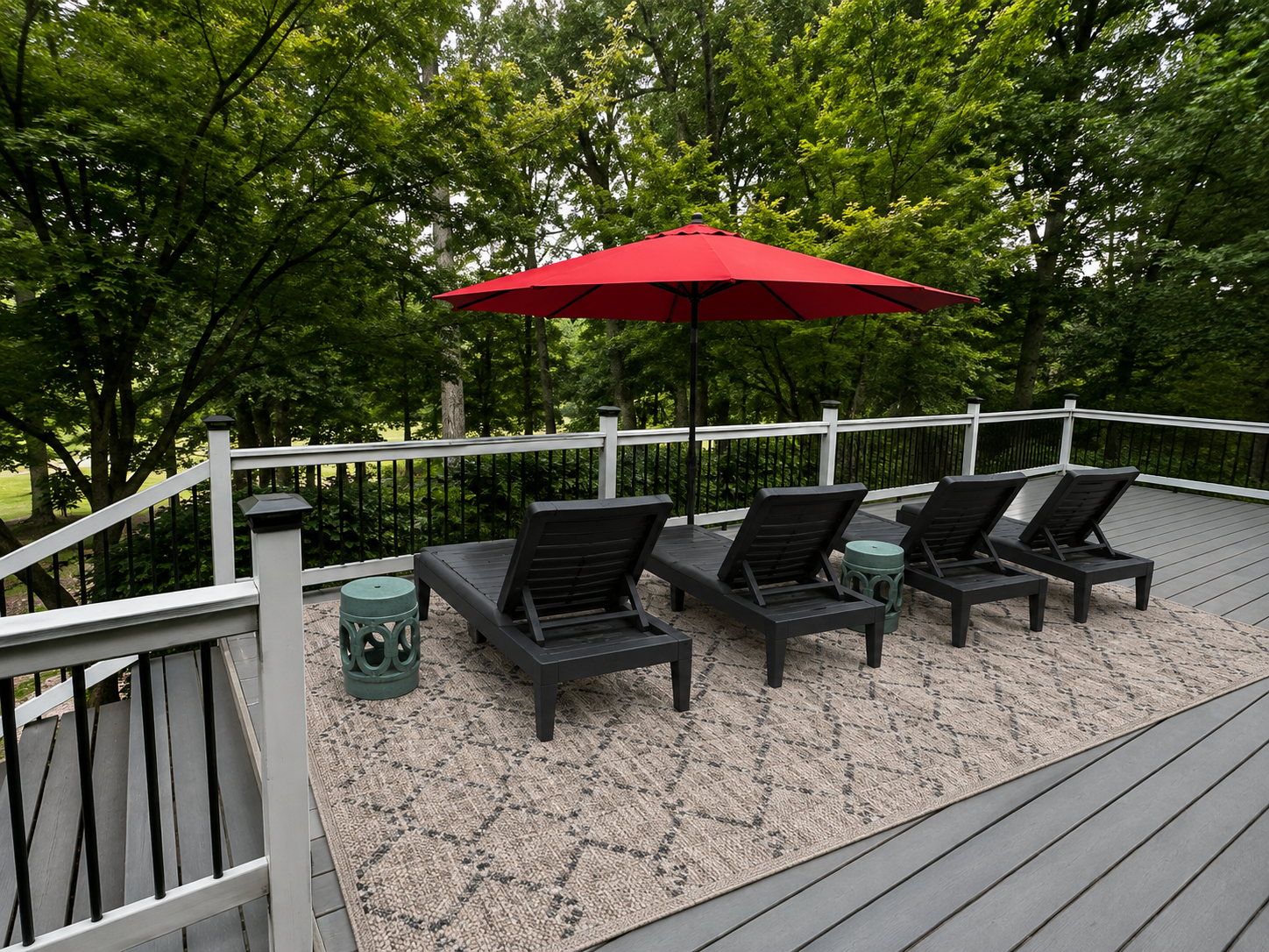 Private wooded deck with lounge chairs and a bright red umbrella