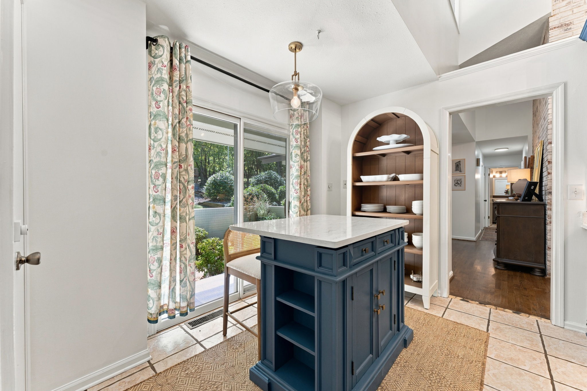 A chef's island anchors the kitchen while an arched nook displays your finest dishes, French doors frame the garden beyond.