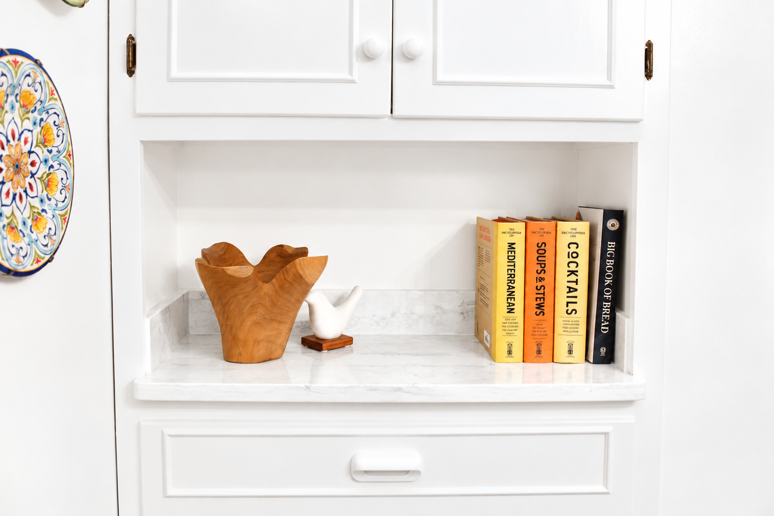 Styled kitchen nook with marble shelf and charming cookbook display