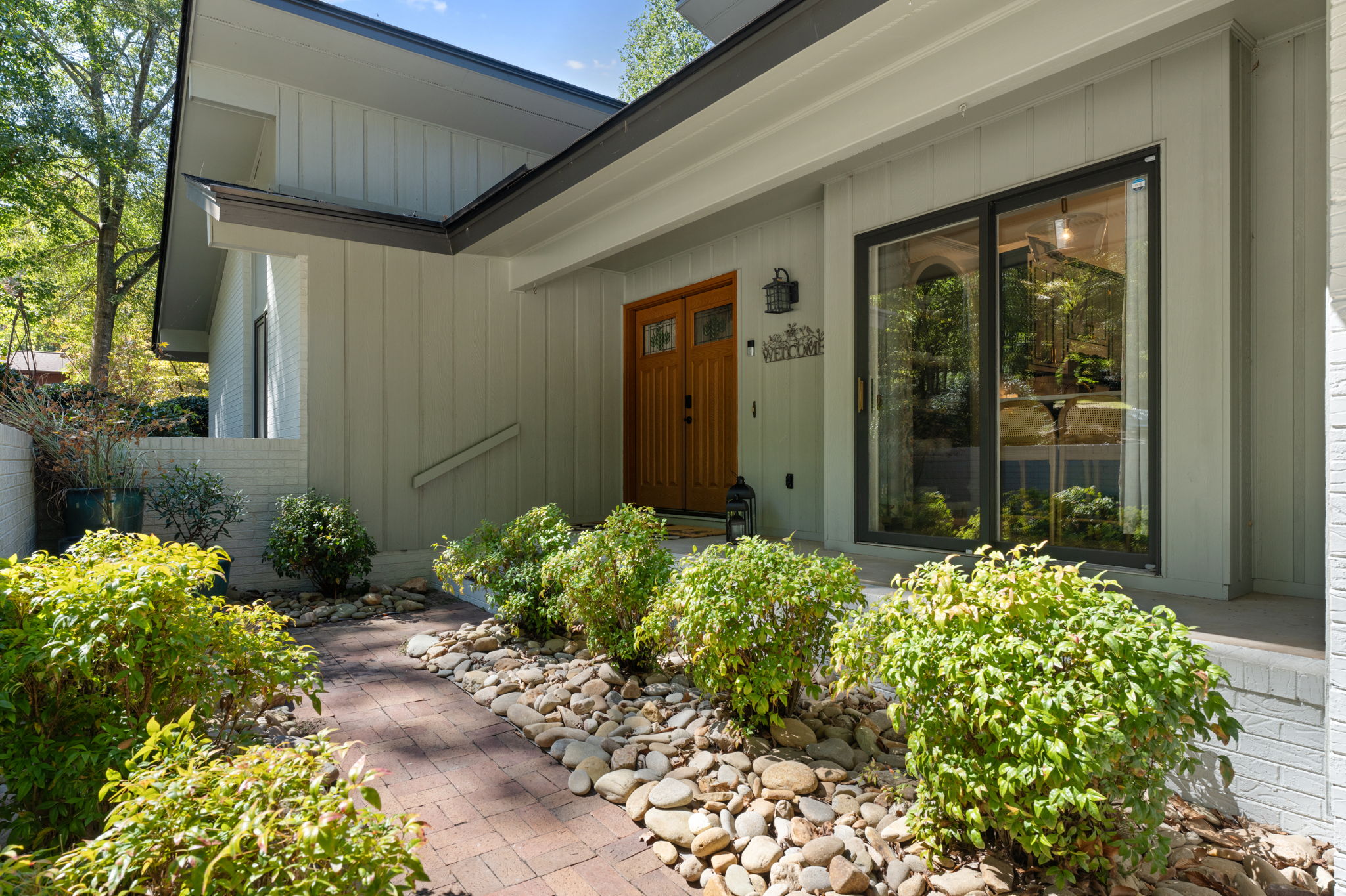 Welcome home: A carved wood door, manicured landscape, and modern architecture set the tone the moment you arrive.
