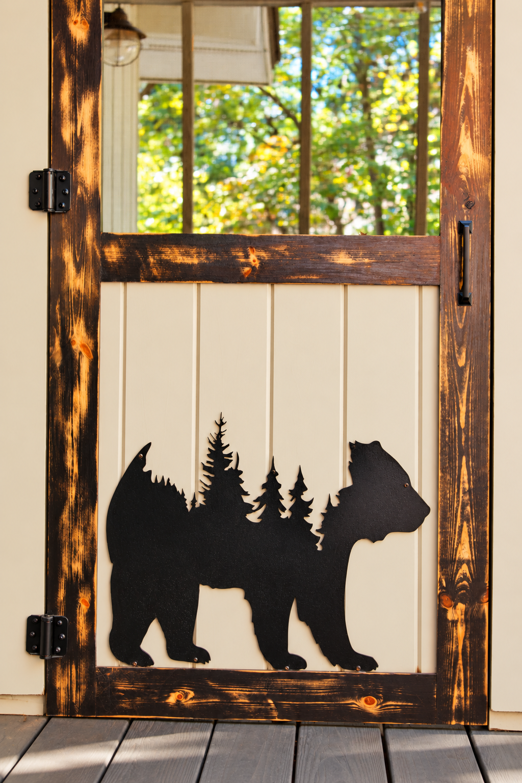 A carved bear holds the forest within its silhouette: even the doors speak the language of this place.