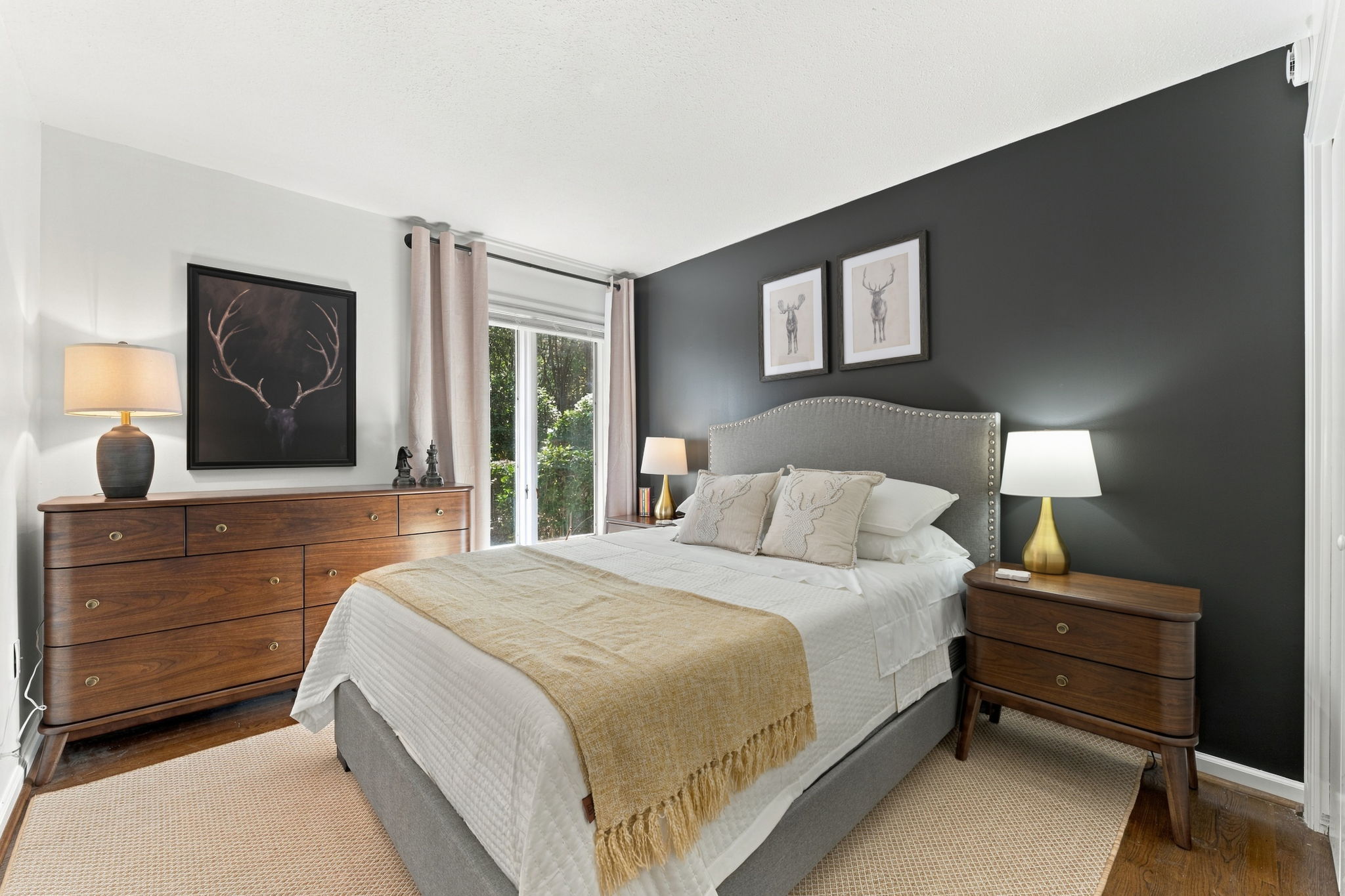 Sophisticated refuge: moody walls, warm wood, and a hushed luxury that makes you want to stay in bed.