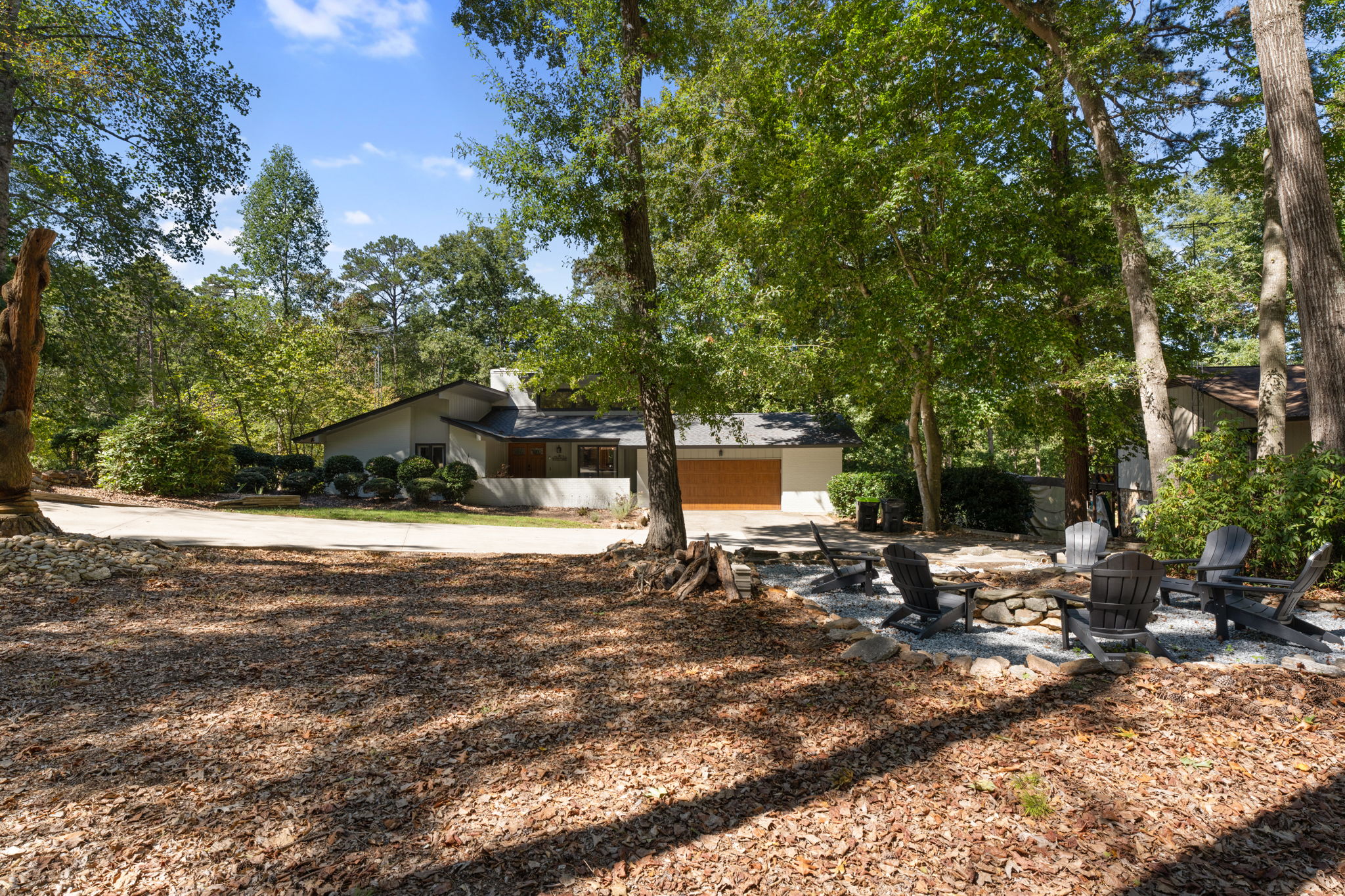 Gather by the fire pit under towering trees: your private wooded retreat awaits when evening falls.