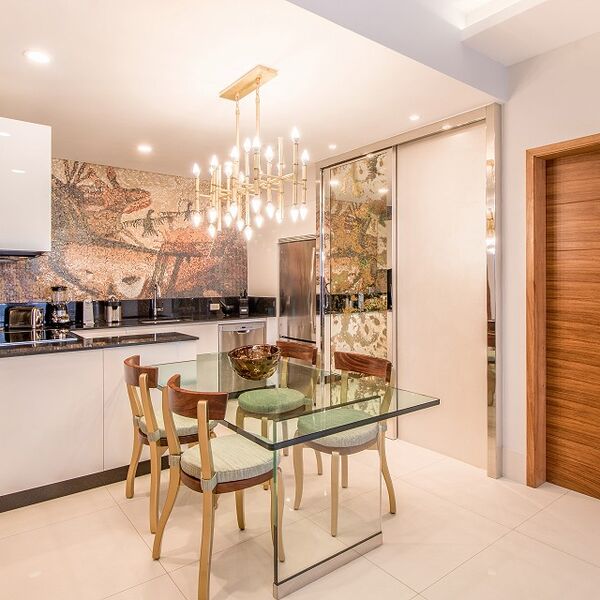 Elegant dining space with designer lighting and sleek modern kitchen