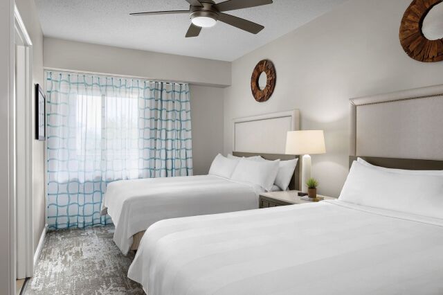 Bright double-queen bedroom with natural light and clean, modern style