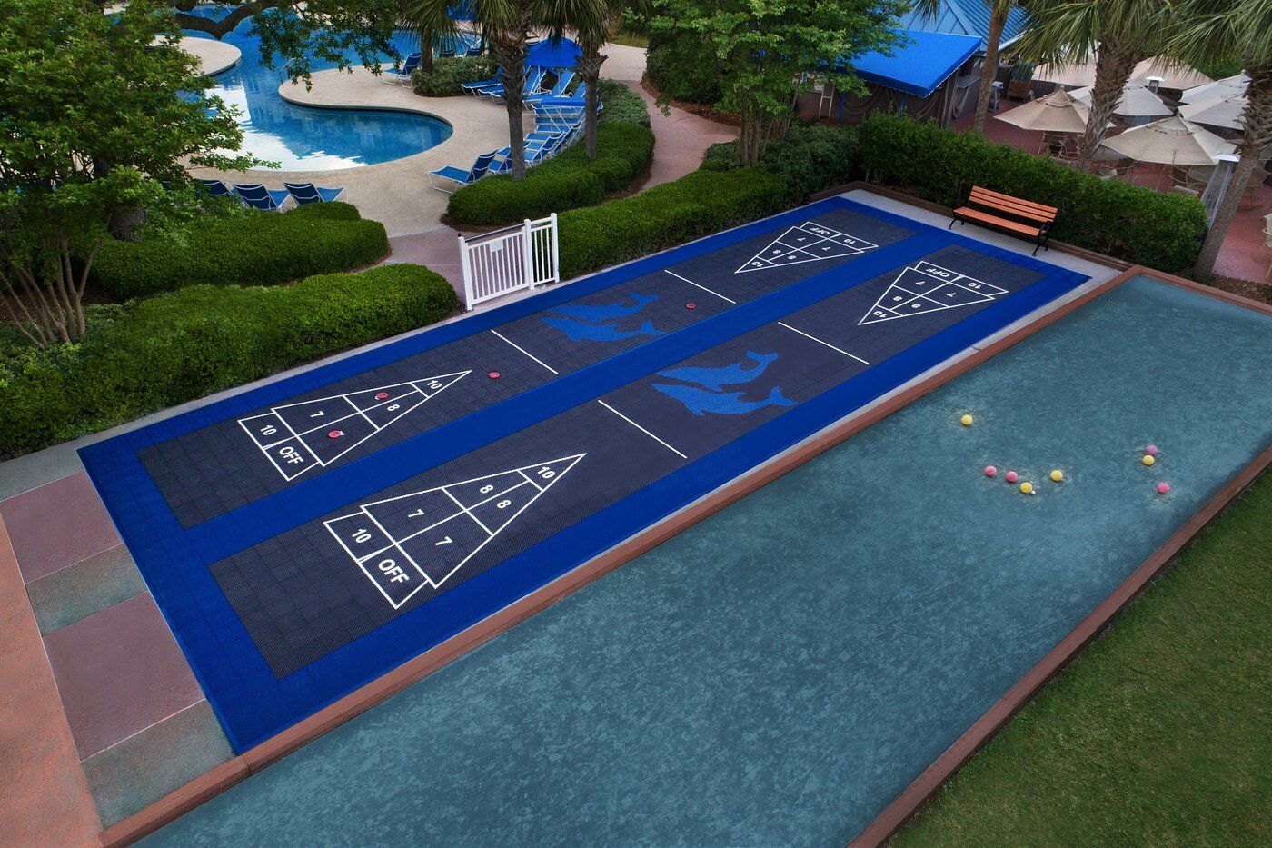 Resort-style outdoor games area with shuffleboard, bocce court, and pool