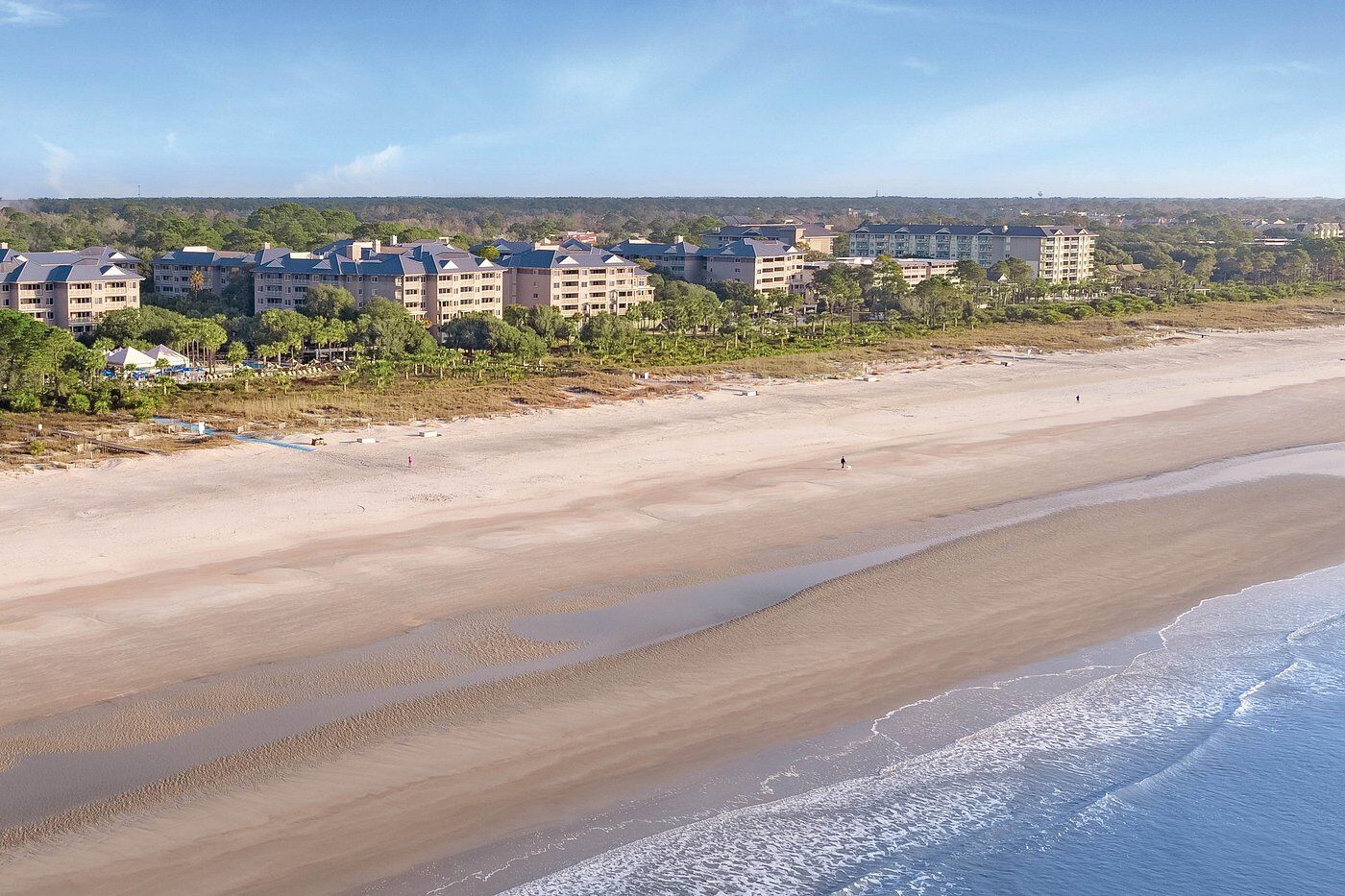 Wide sandy beachfront with resort-style condos and peaceful coastal views