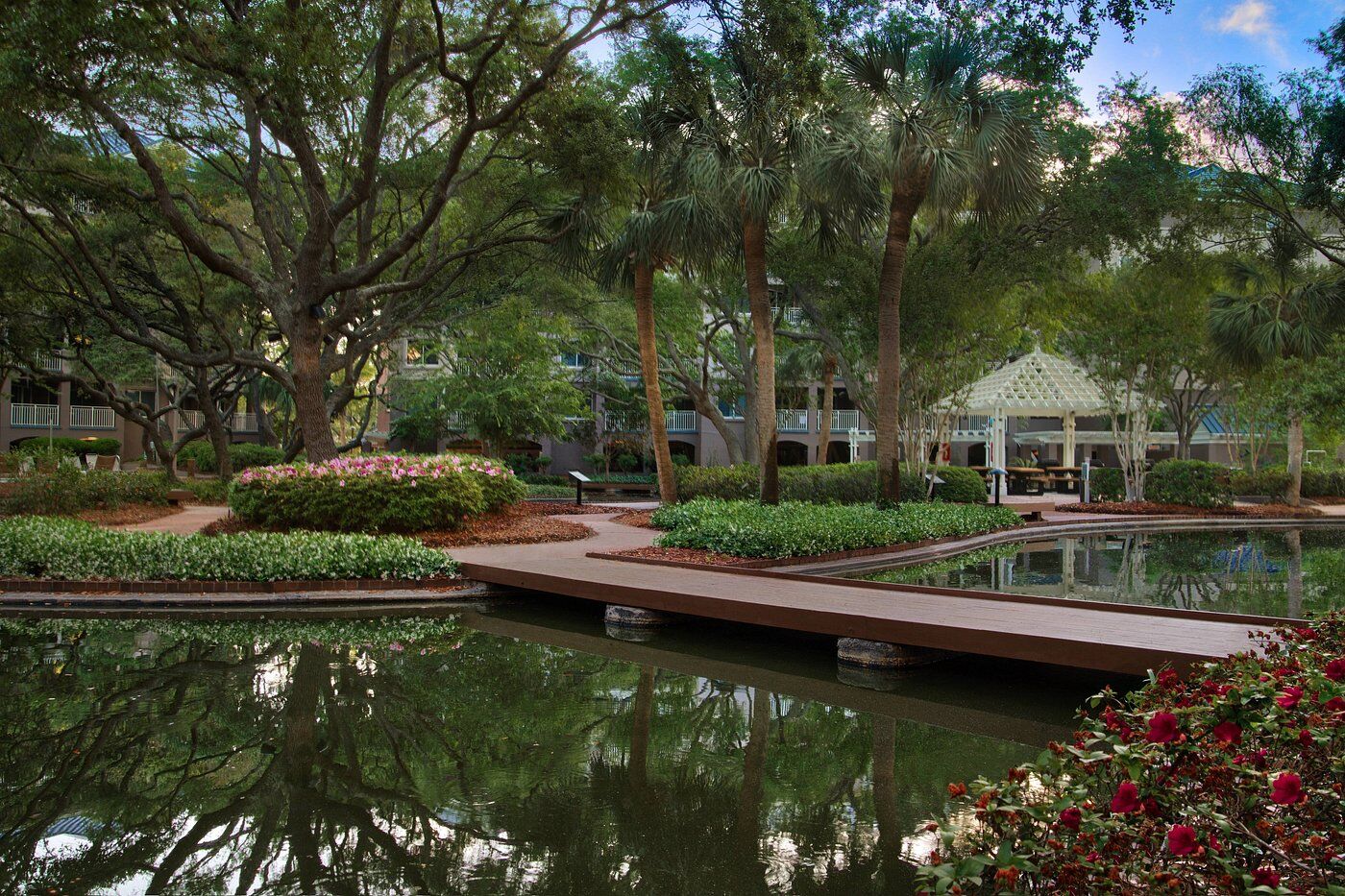Lush courtyard with reflecting ponds, boardwalk paths, and a charming gazebo