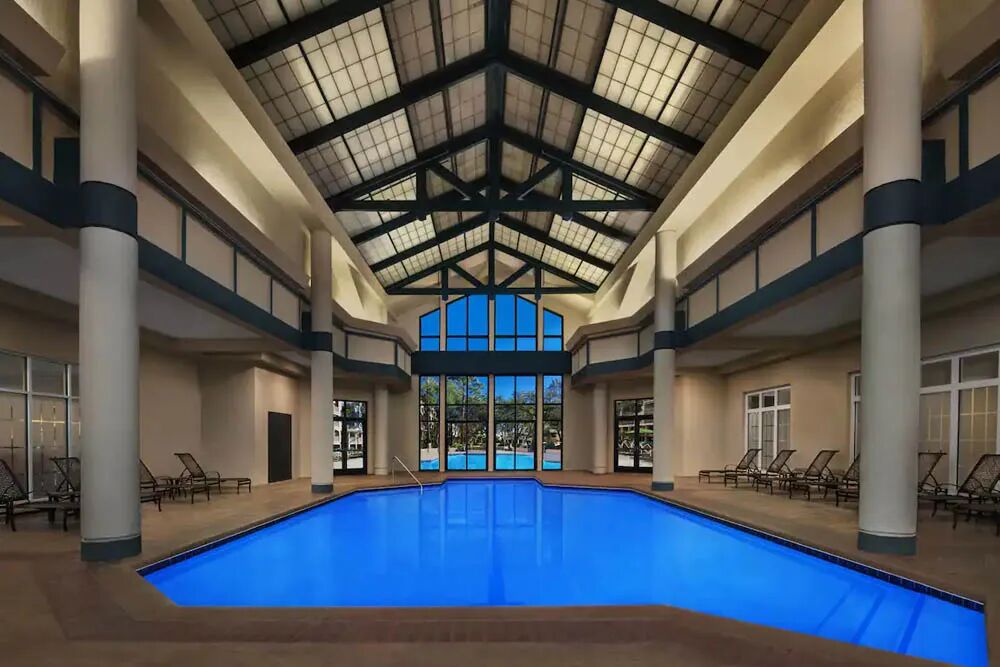 Resort-style indoor pool with vaulted ceilings and relaxing lounge seating