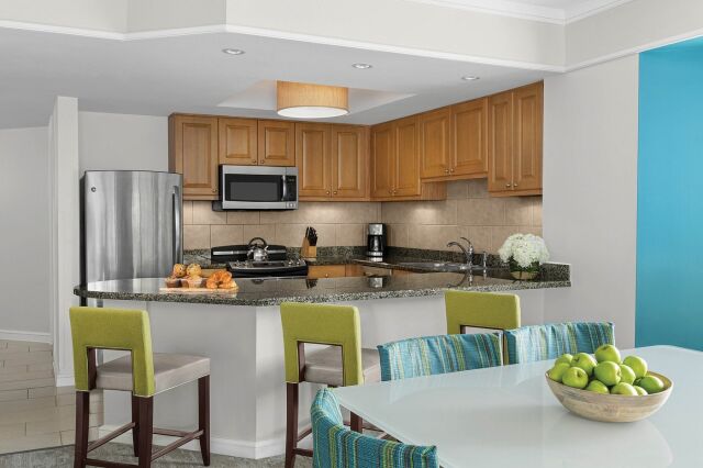 Bright open kitchen with granite bar, stainless appliances, and chic dining area