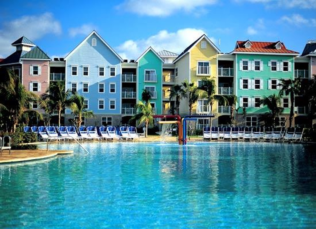 Resort-style pool with colorful condos and a sunny tropical vibe