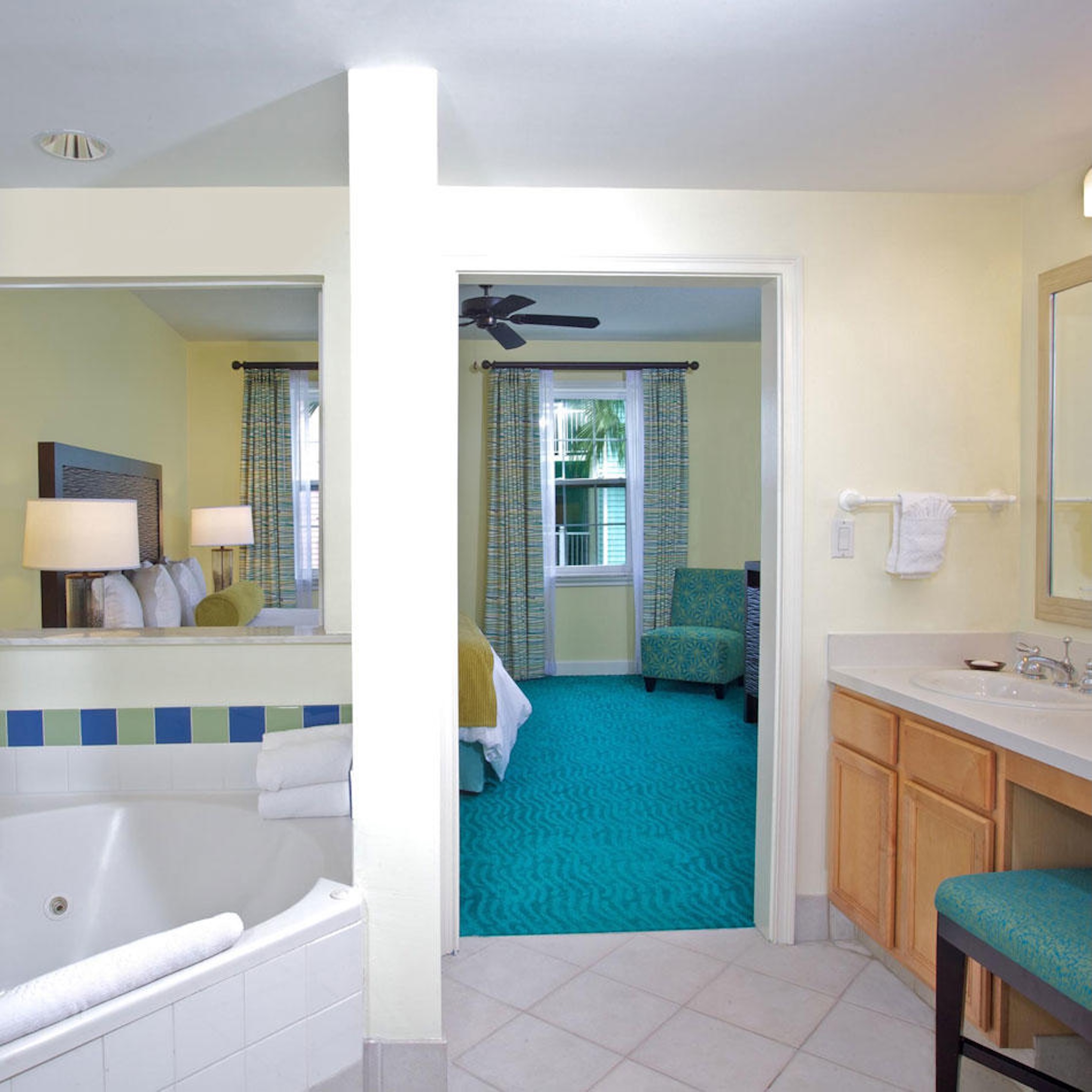 Bright ensuite with soaking tub, roomy vanity, and direct bedroom access
