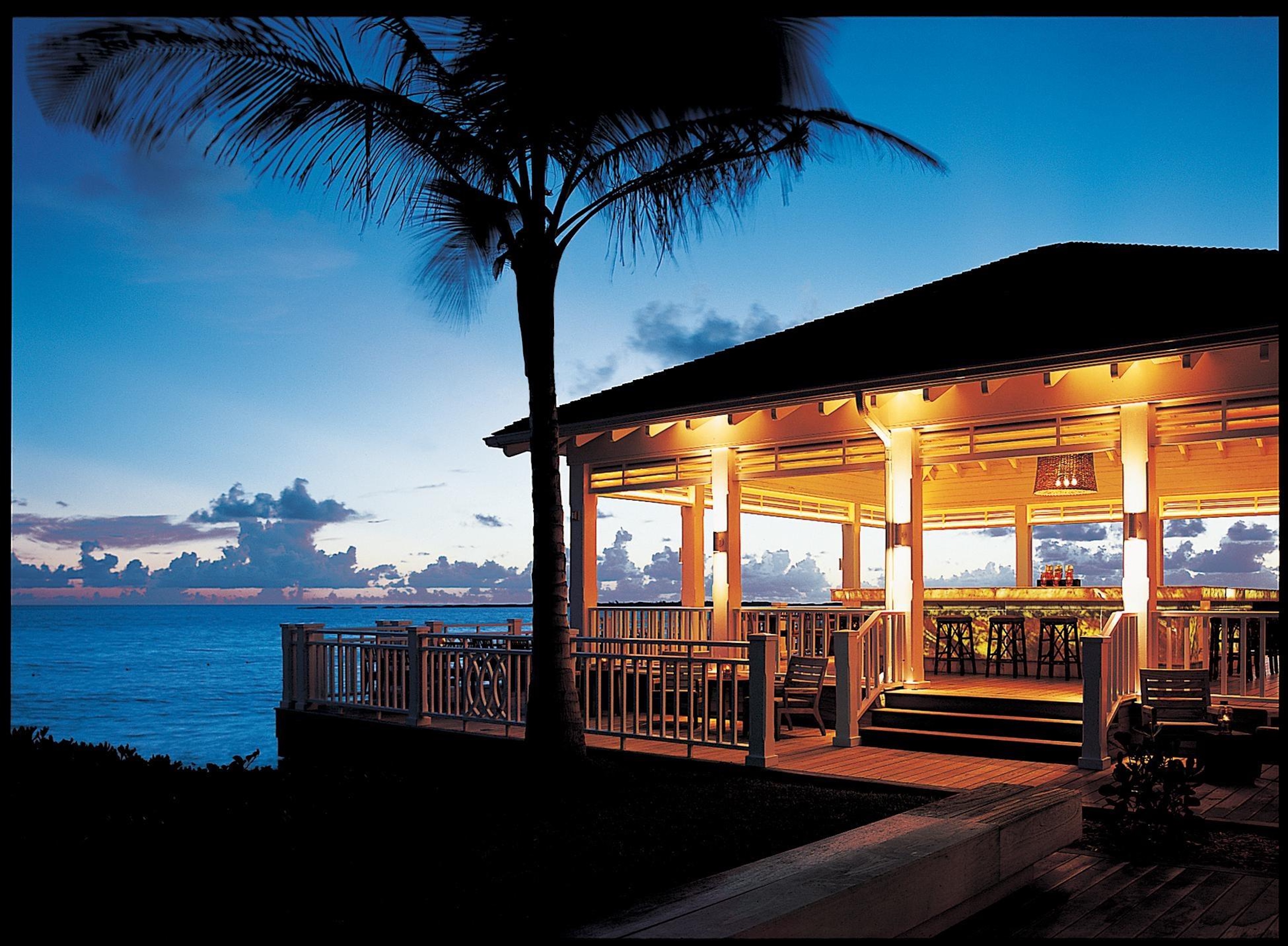 Waterfront sunset pavilion with tropical ocean views and warm evening ambiance