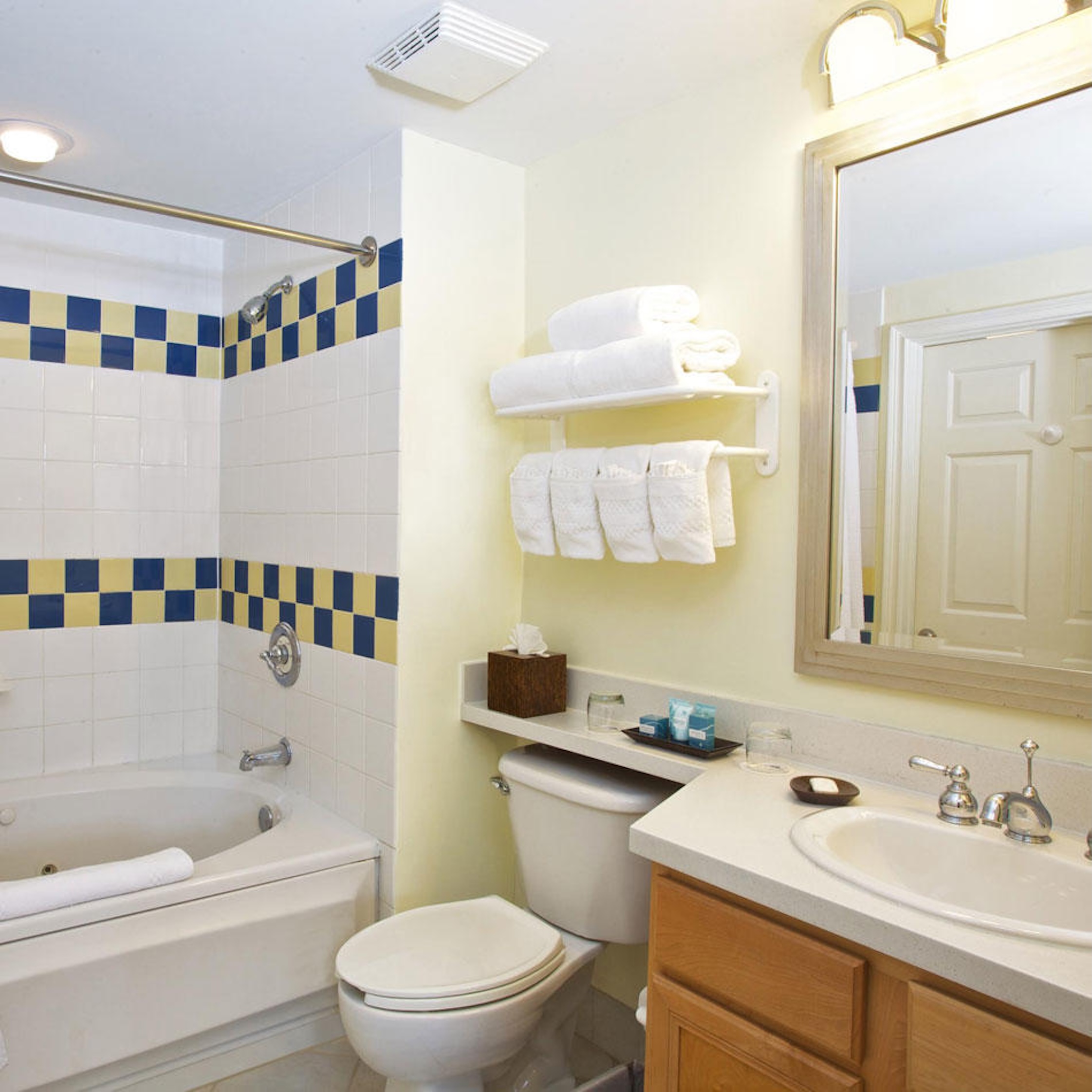 Bright full bathroom with tub/shower combo and fresh towel storage