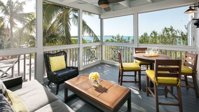 Screened tropical porch with dining space and peaceful water views