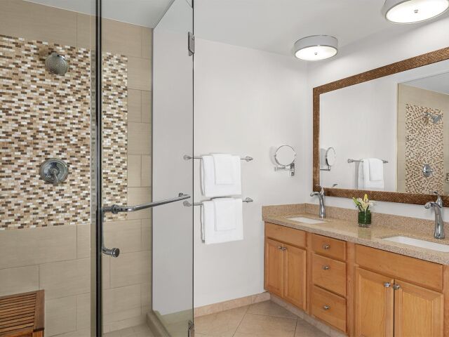 Bright spa-like bathroom with dual sinks and glass walk-in shower