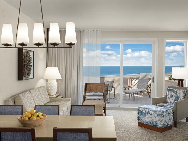 Bright coastal living room with private balcony and stunning ocean views
