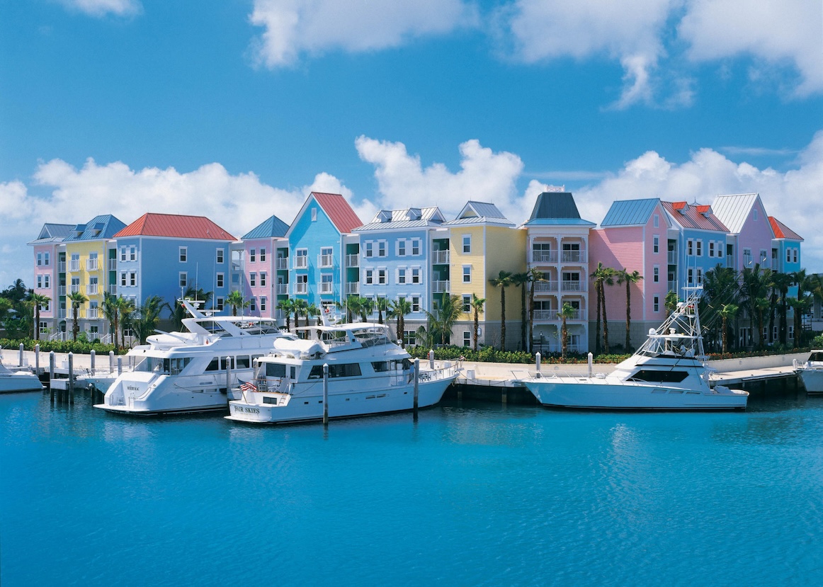 Colorful marina-front retreat with yachts, palm trees, and tropical views
