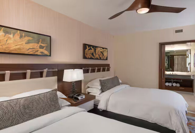 Bright double-queen room with modern décor and a convenient vanity area