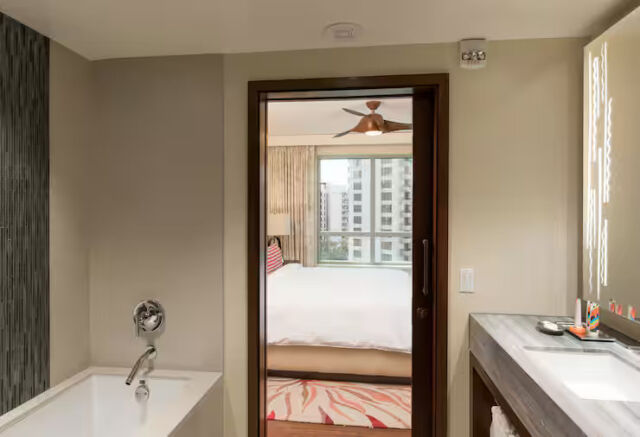 Modern spa-style bath with soaking tub and bedroom city-view connection