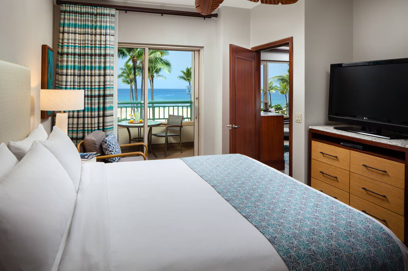 Cozy oceanview bedroom with private balcony and tropical beach views