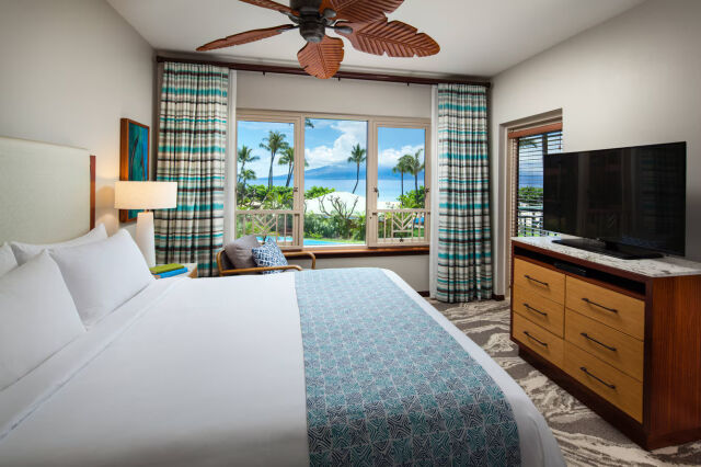 Bright coastal bedroom with ocean views and a plush king bed