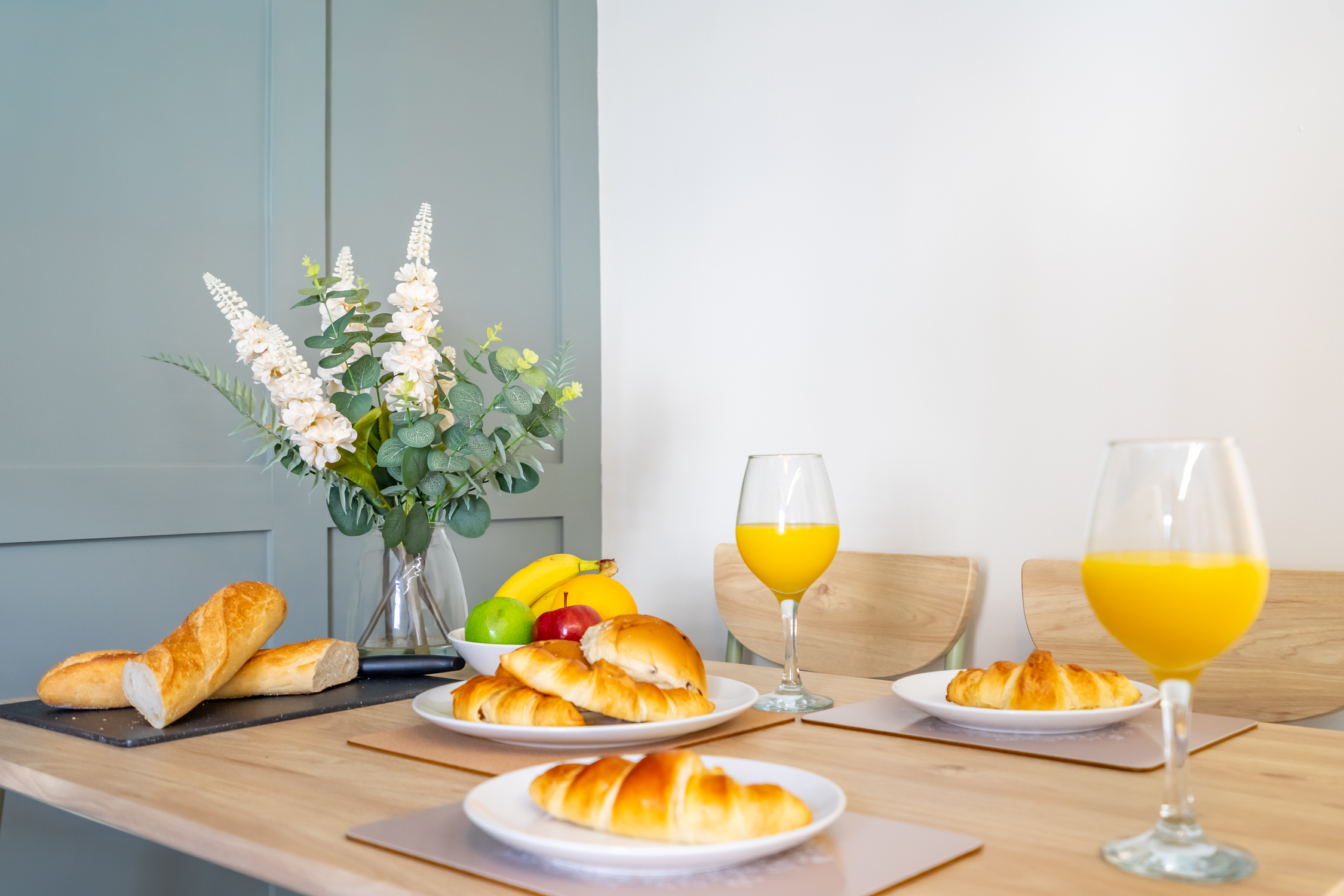Bright breakfast setup with fresh pastries, fruit, and a cheerful dining space