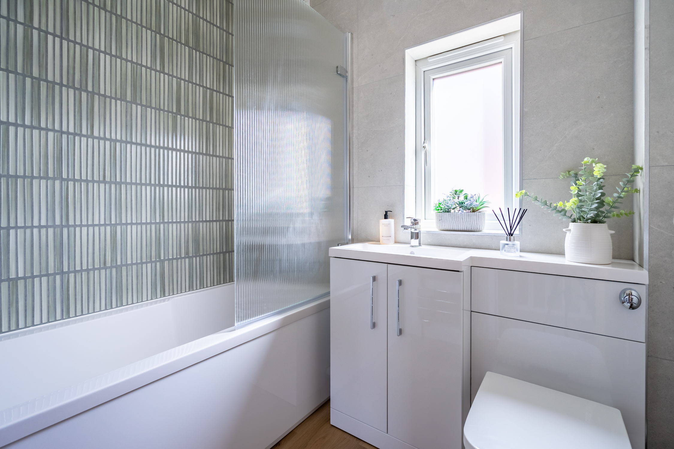 Bright modern bathroom with tub, privacy glass, and fresh natural light