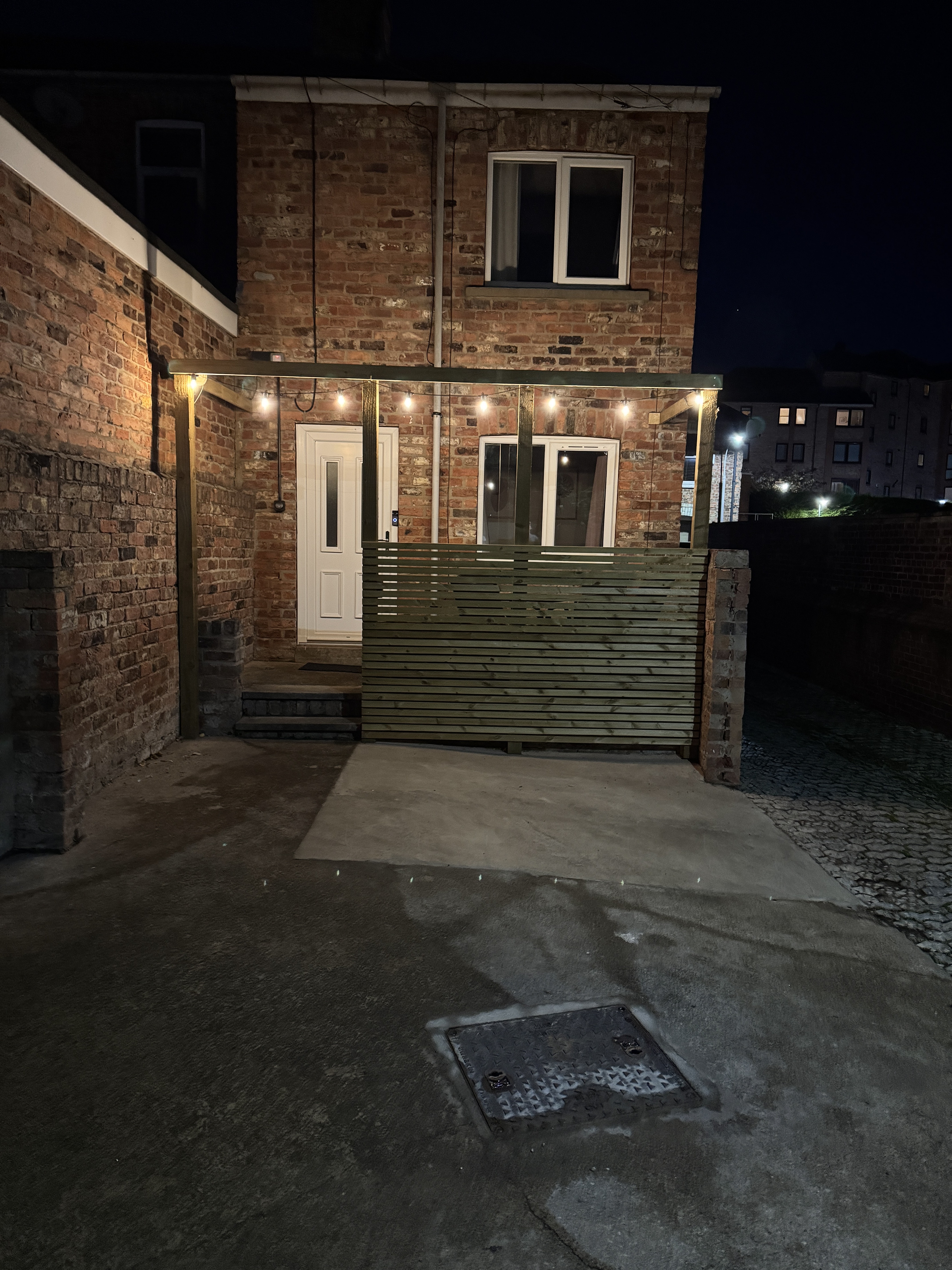 Cozy private patio entrance with warm evening lighting