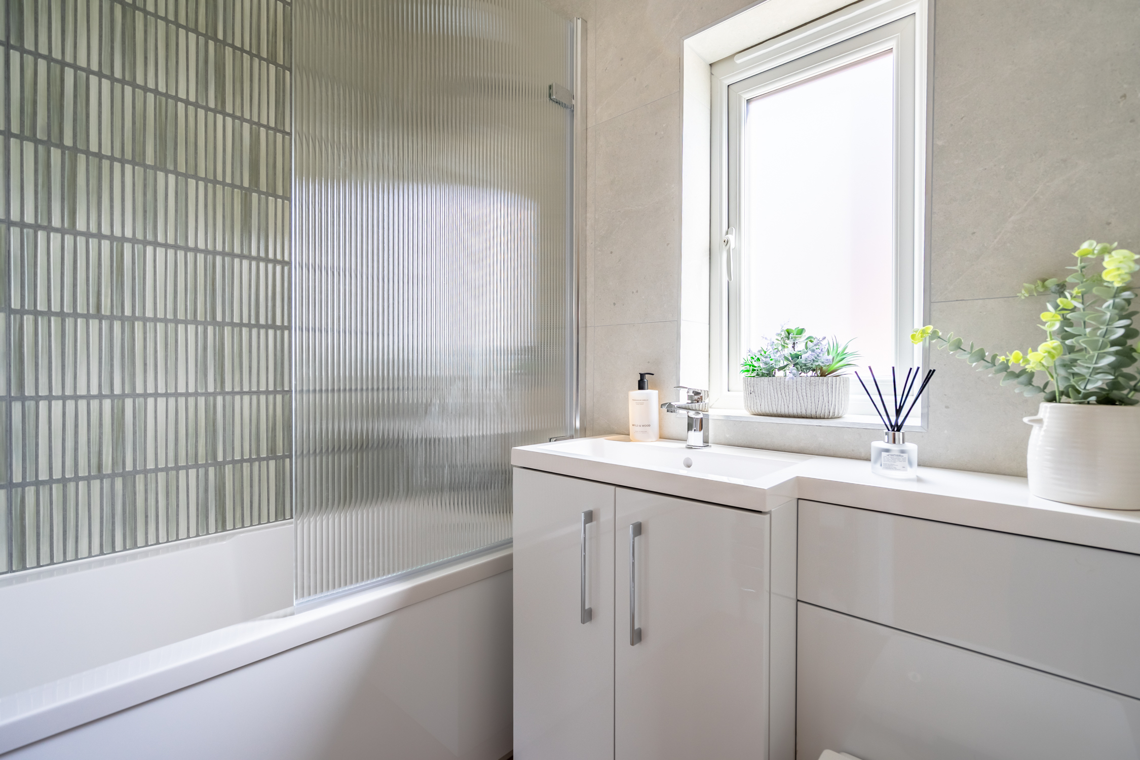 Bright modern bathroom with tub, natural light, and sleek finishes