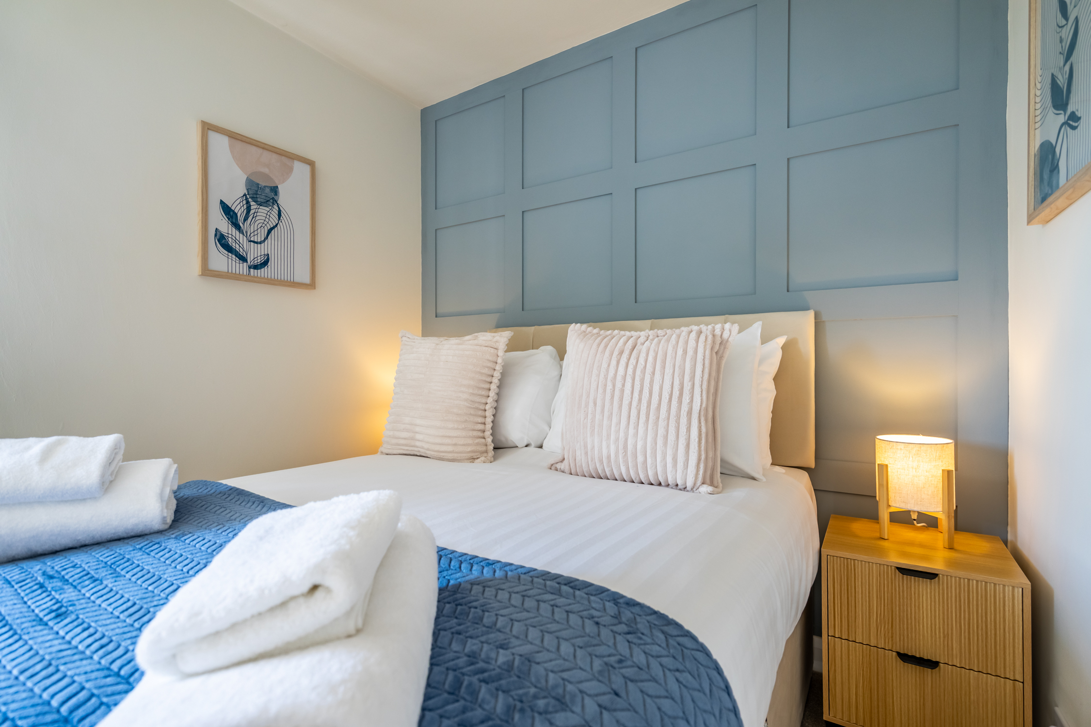 Stylish cozy bedroom with blue feature wall and soft ambient lighting