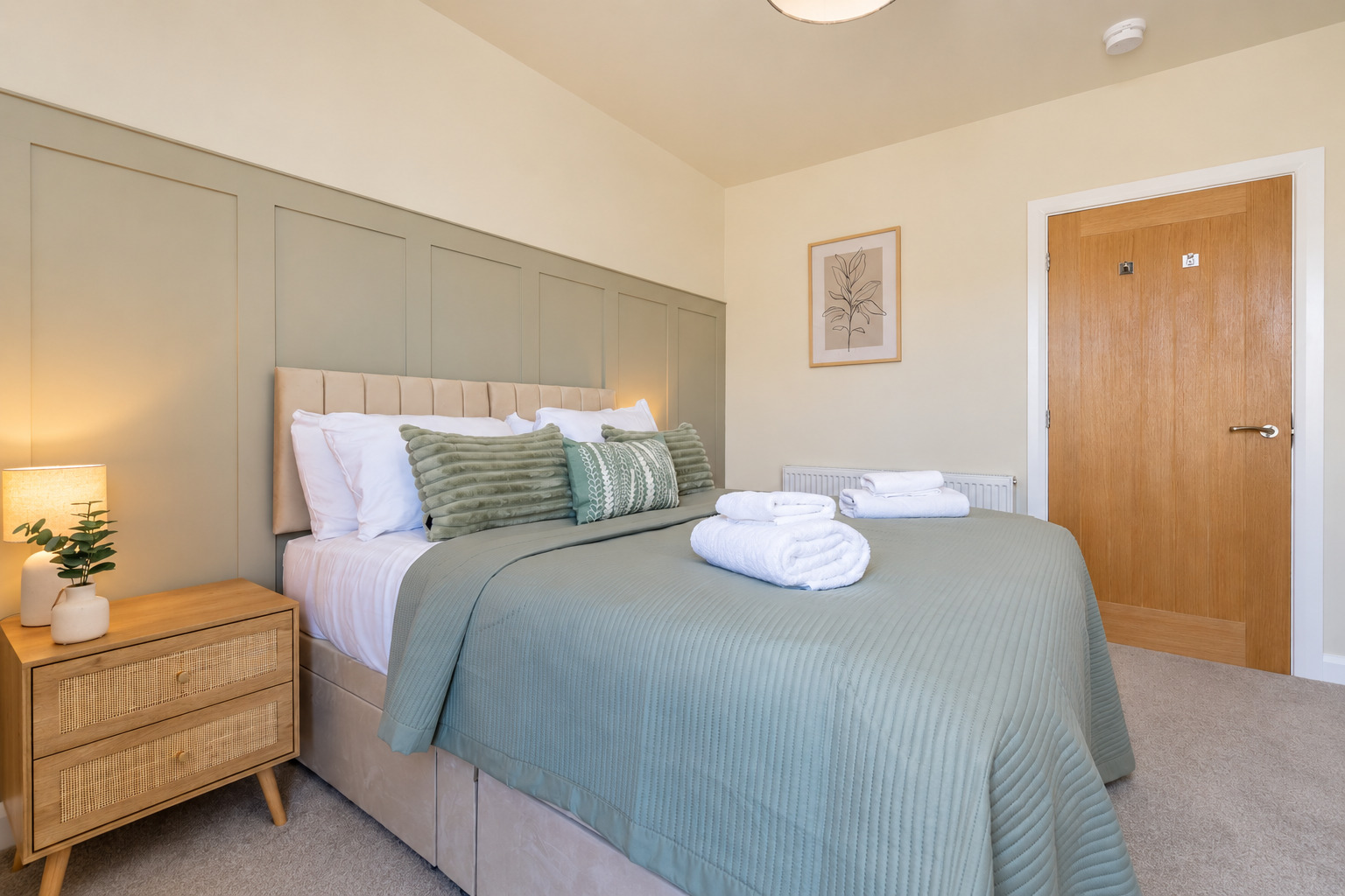 Calm, stylish bedroom with plush bedding and fresh towels