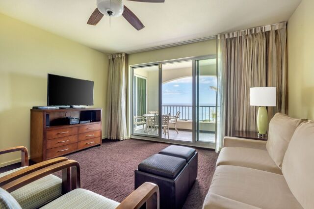 Bright living room with ocean-view balcony and outdoor dining