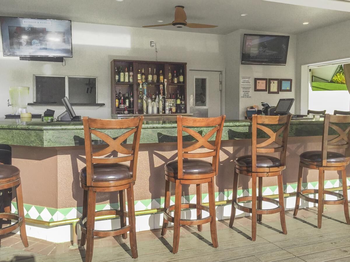 Open-air bar with TVs, high-top seating, and a relaxed resort-style vibe