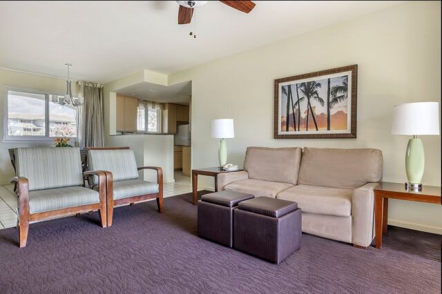 Bright open living room with cozy seating, dining area, and full kitchen access