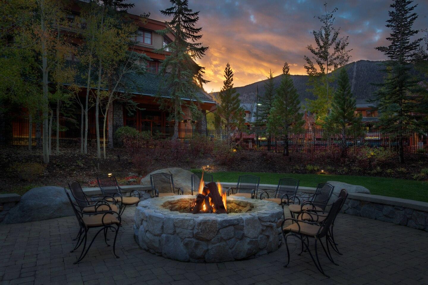 Cozy stone fire pit courtyard with mountain views at sunset