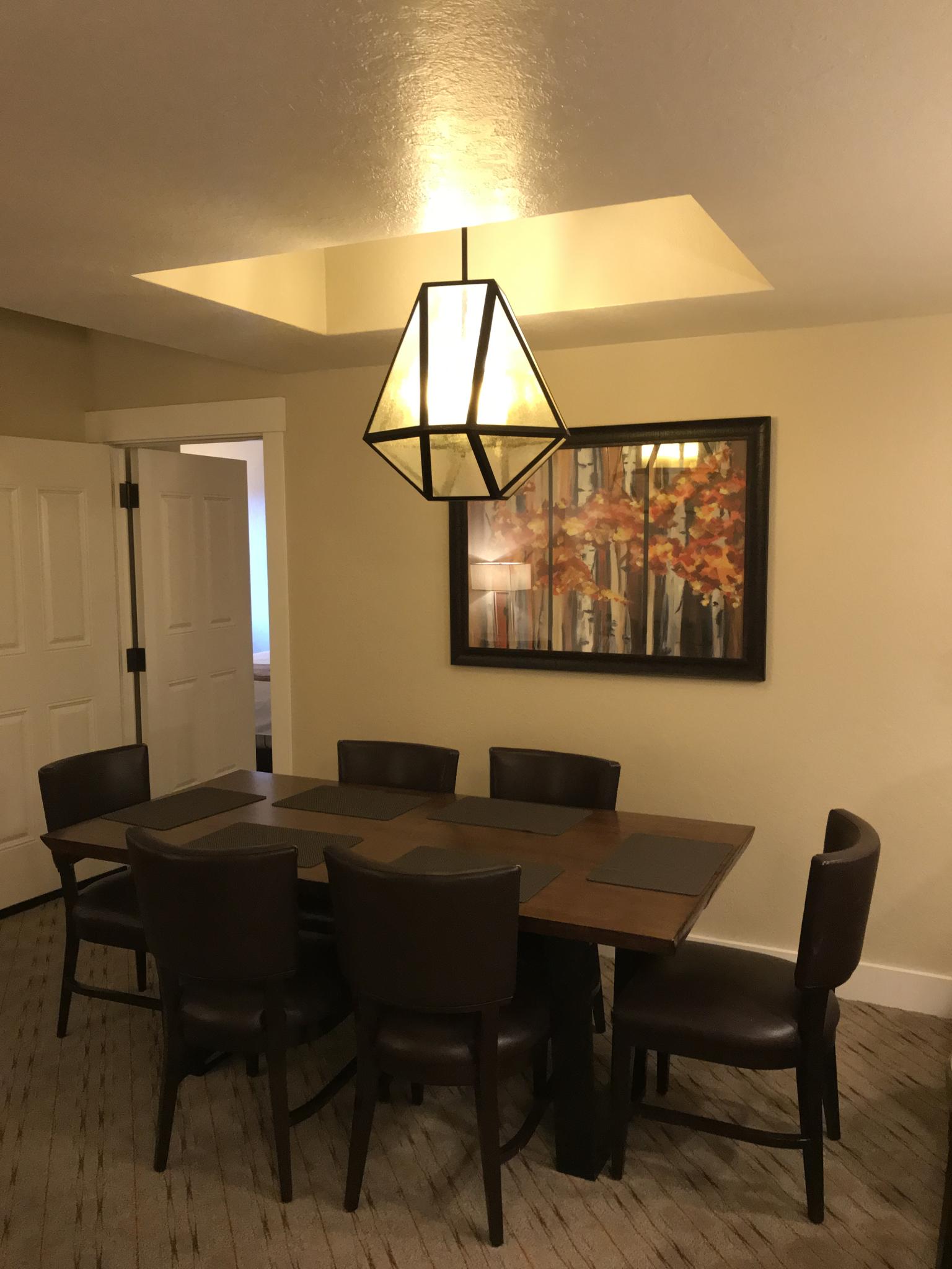 Warm dining room with seating for 6 and stylish modern lighting